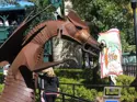 Colour photo of a metal sculpture of a dragon called Dragon Fyre created by artist Bill Lishman. The sculpture is outside and lady is in the background.